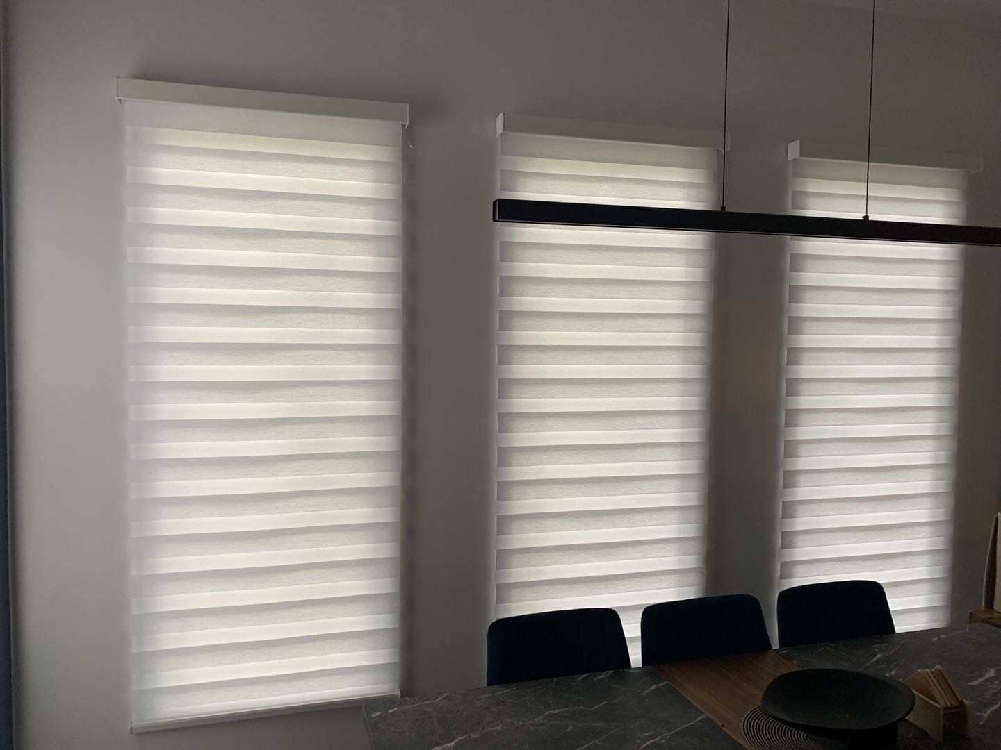 Dining area with three windows and daylight zebra blinds