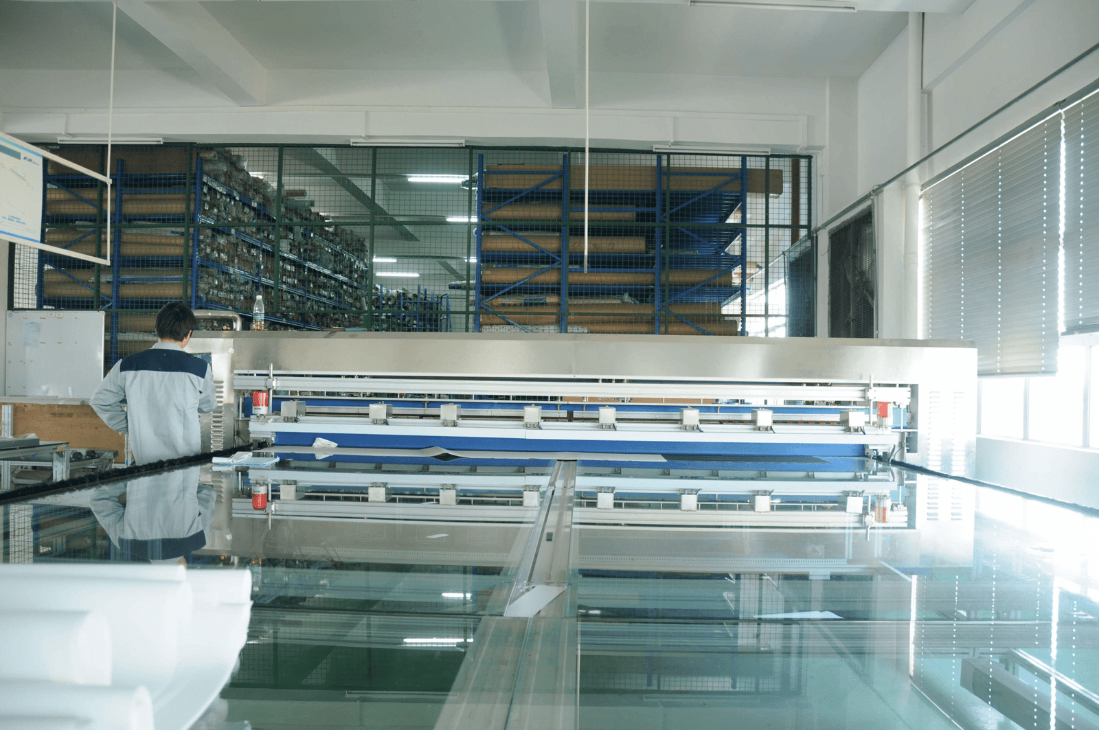 Worker in factory operating machinery, producing high-quality window coverings