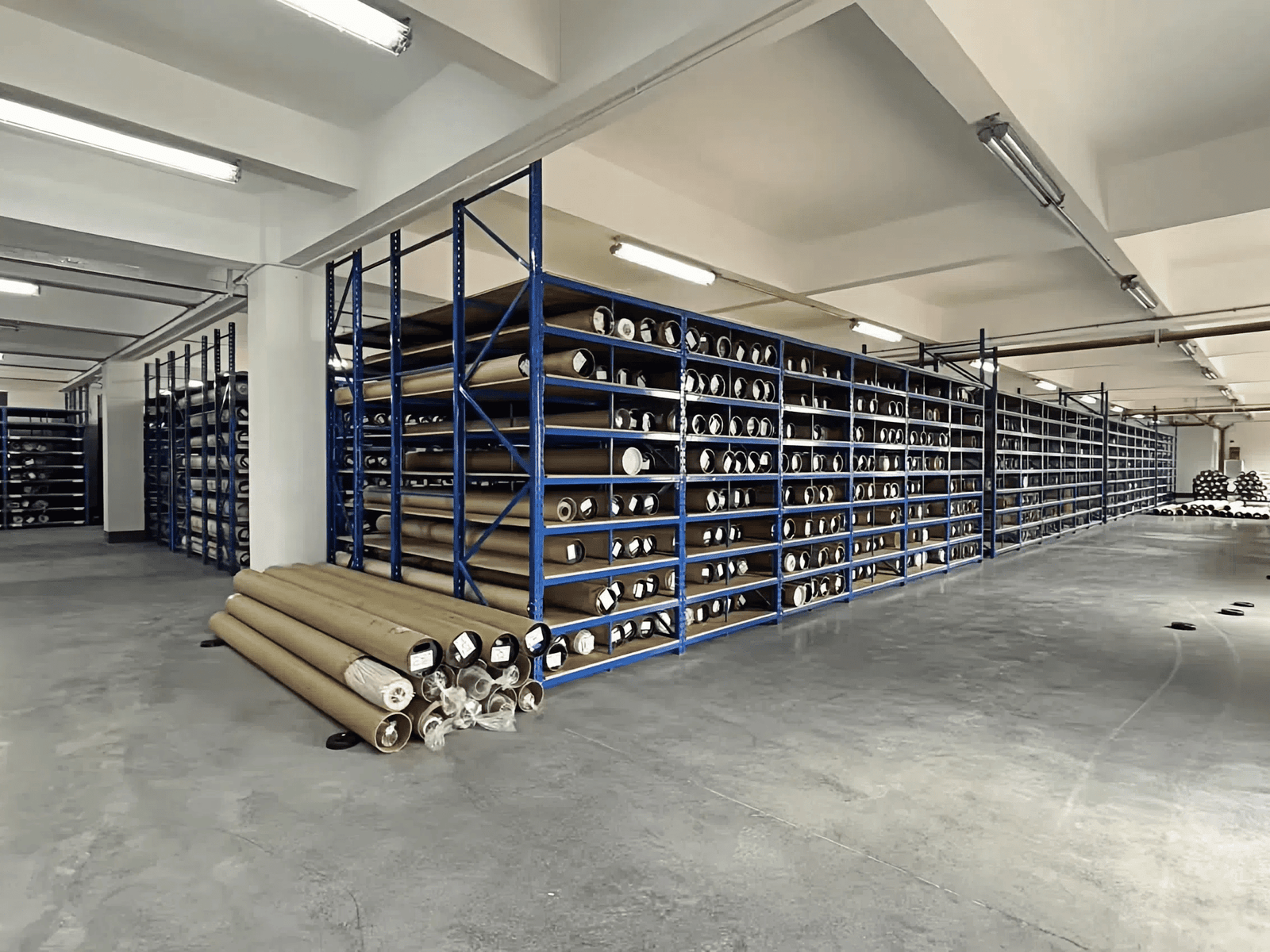 Fabric storage room with rolls of blind textiles on racking