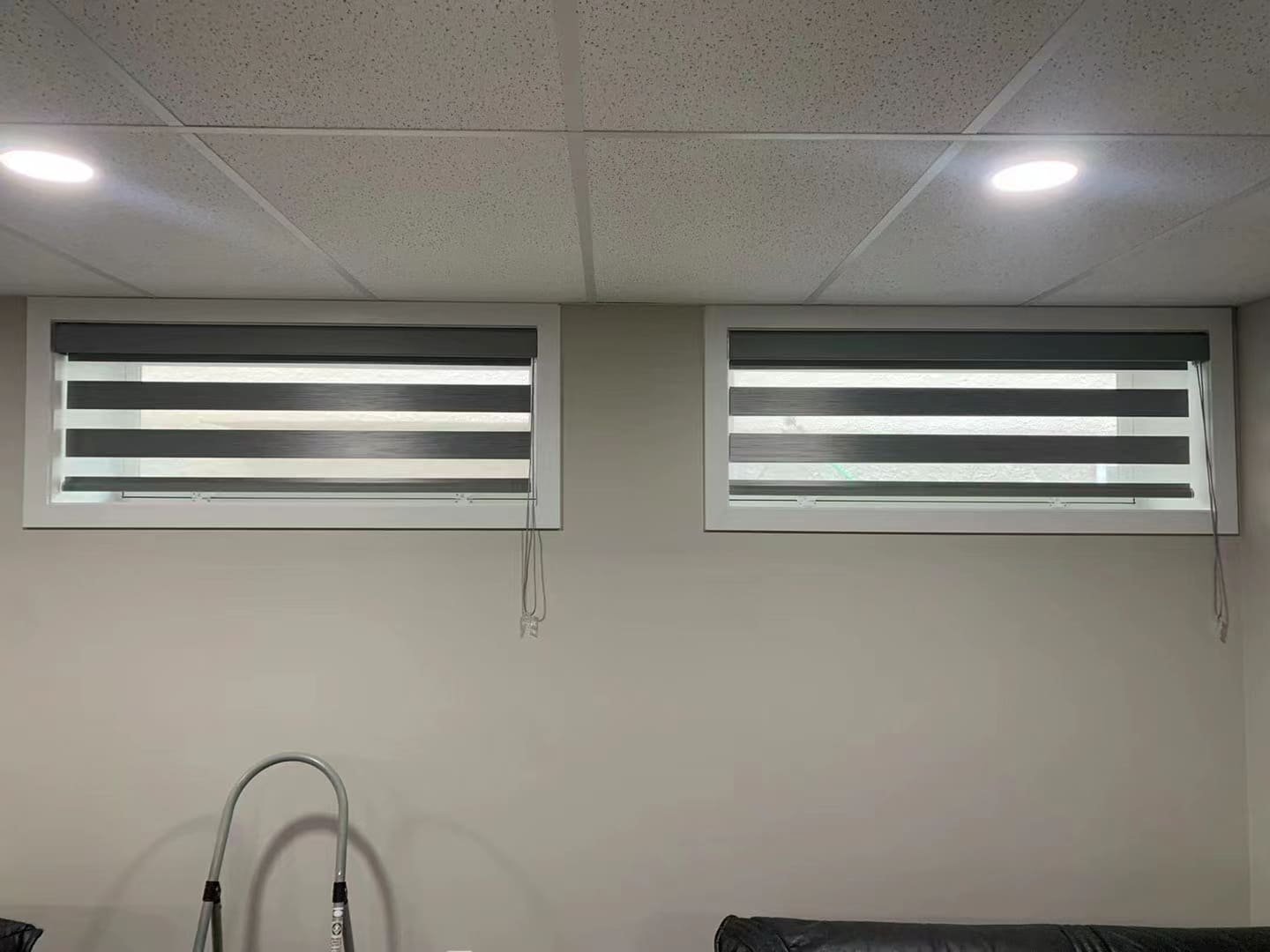 Basement windows with gray zebra blinds installed