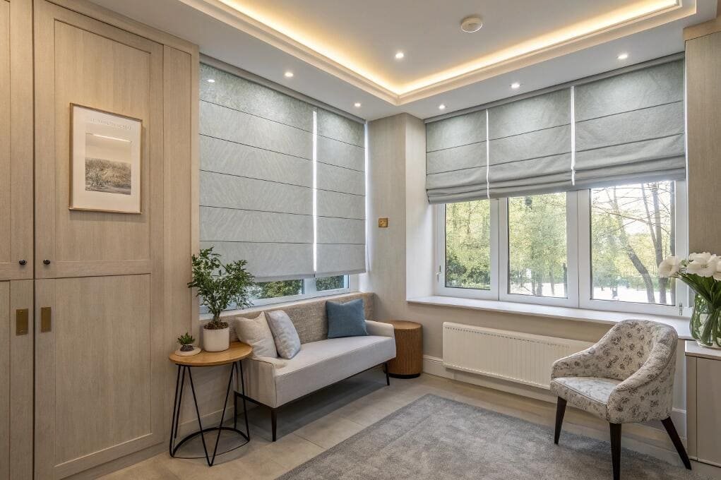 Elegant lounge area featuring light blue Roman blinds on large windows.
