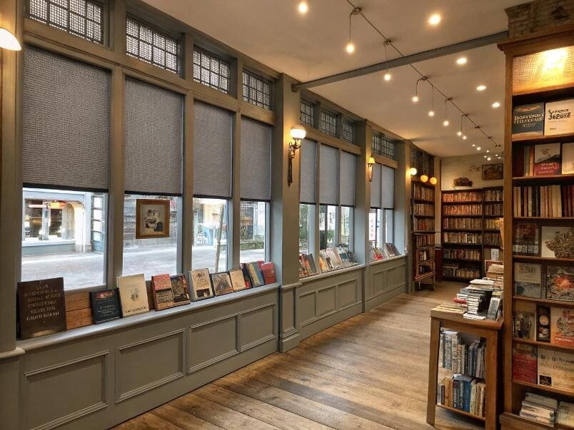 Vintage bookstore with grey solar roller shades
