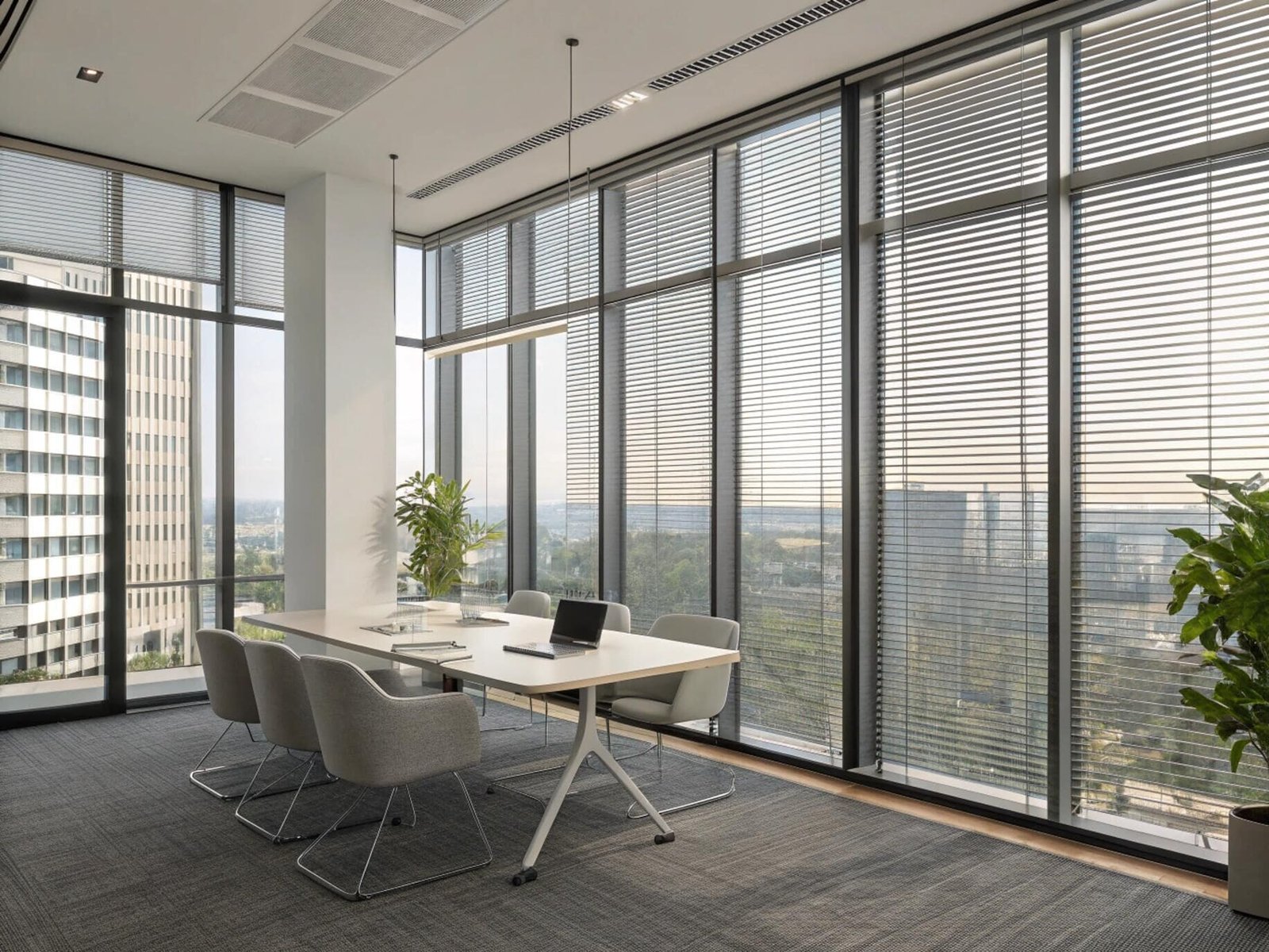 Modern office conference room with motorized venetian blinds for privacy and light control.