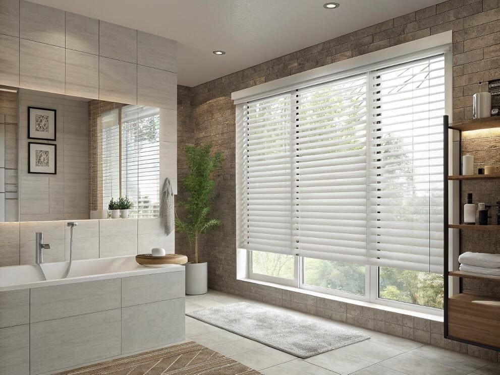 Moisture-resistant white faux wood blinds provide excellent privacy and light control for bathrooms.