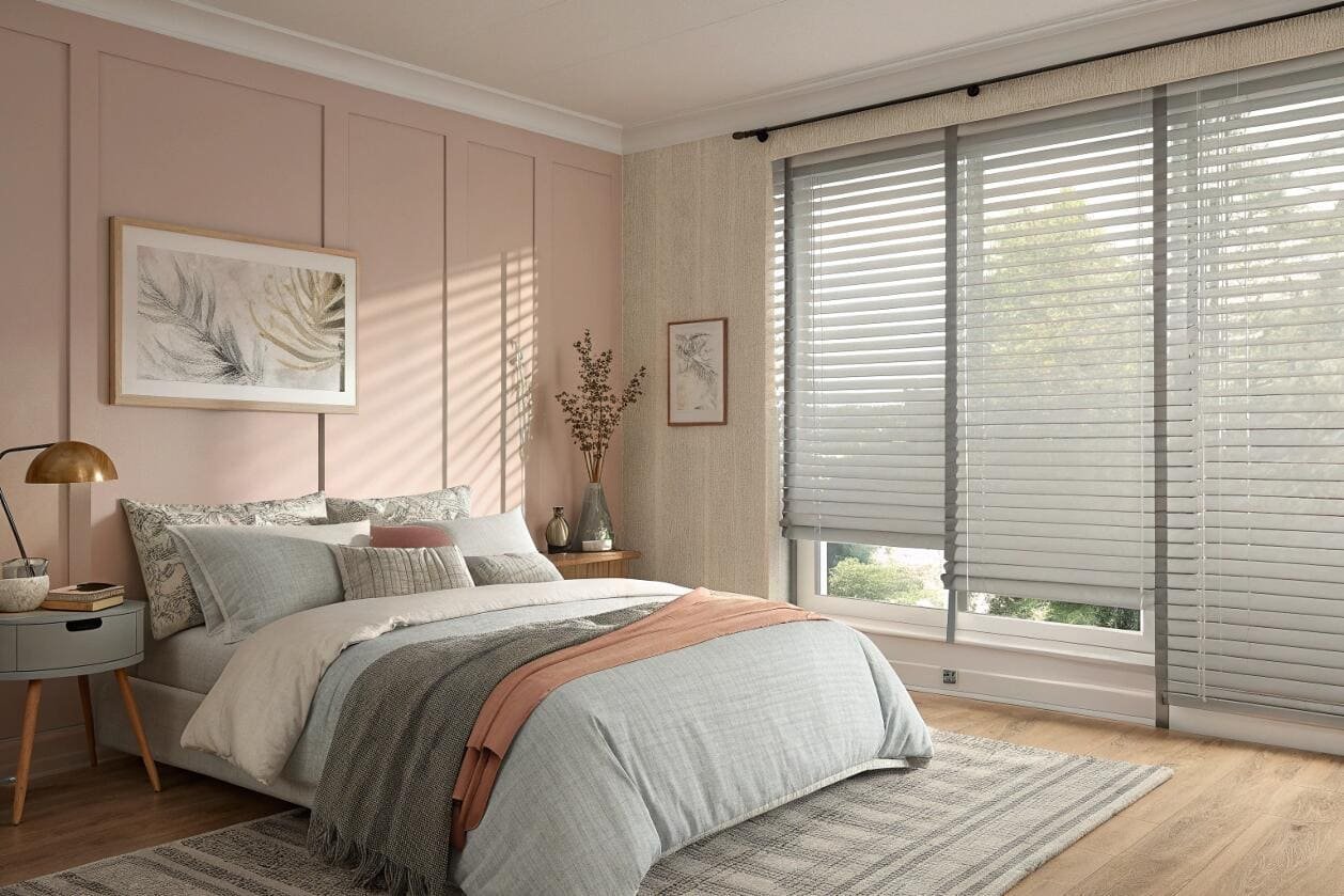 Stylish bedroom showcasing grey venetian blinds against a pink wall.