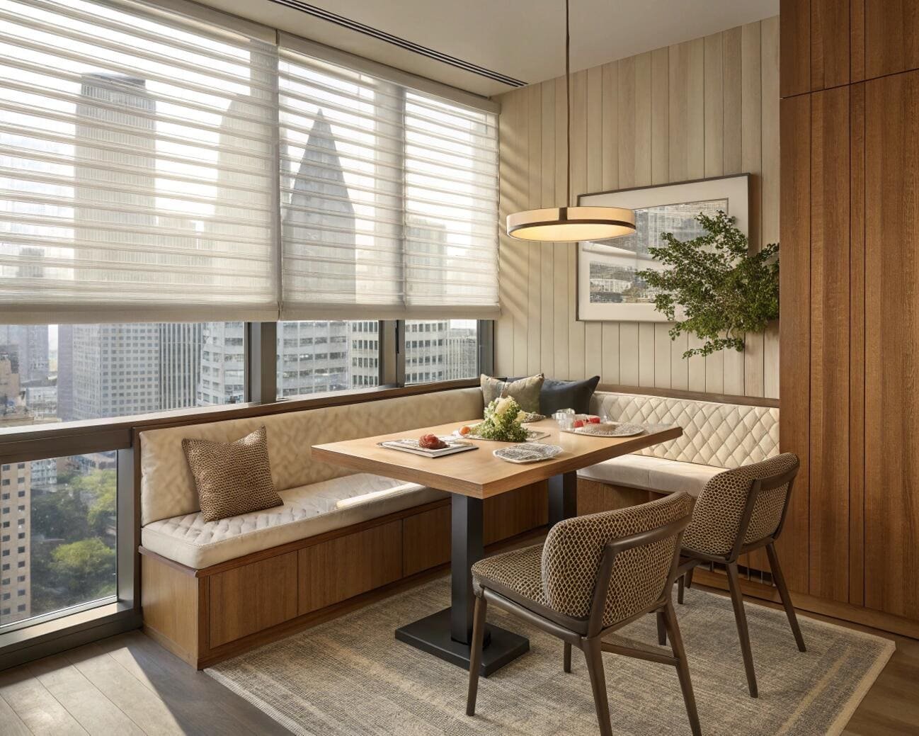 Contemporary dining space with urban views and sleek sheer window blinds.