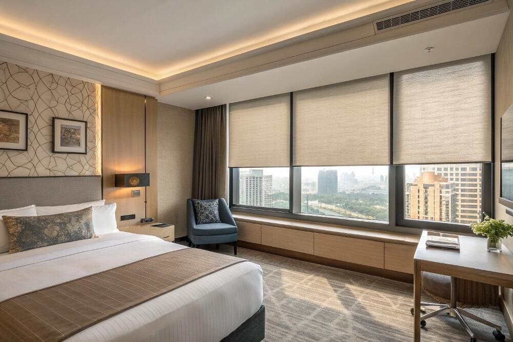 Light-filtering roller shades provide a sleek, modern finish for luxury hotel rooms.