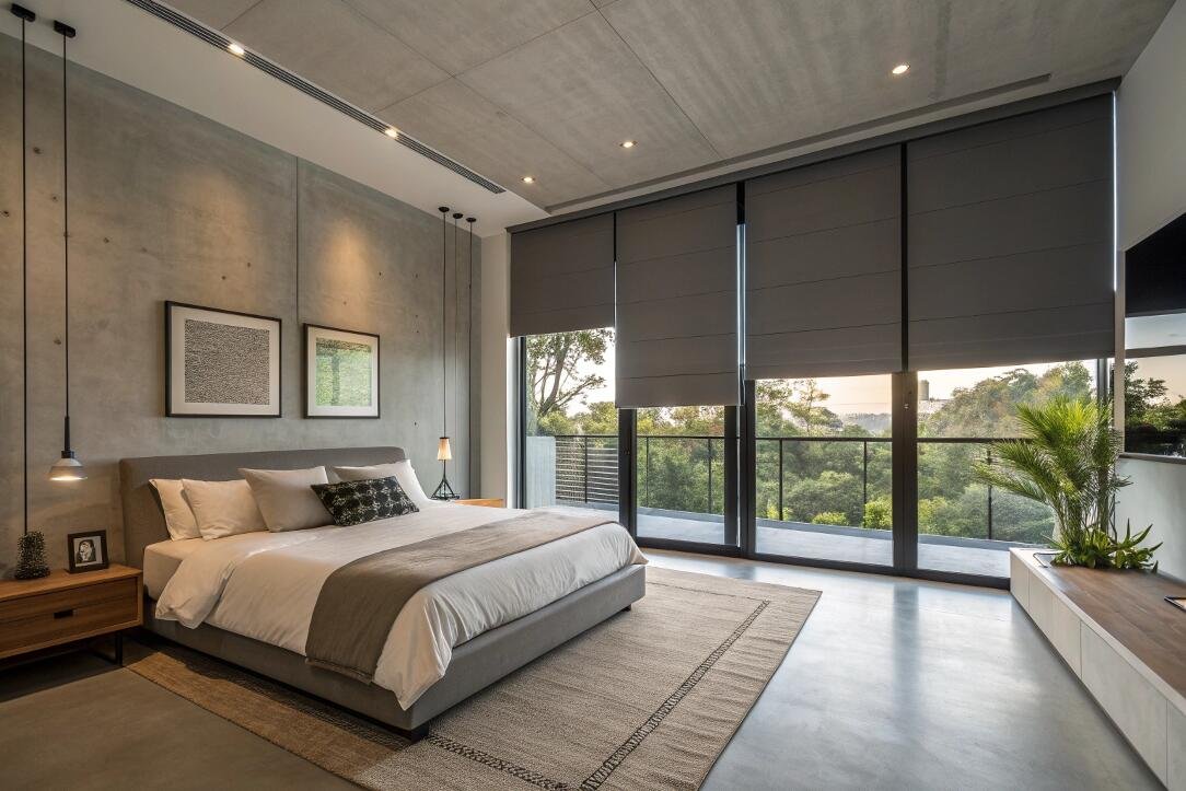 Blackout Roman shades provide complete light control for a modern, industrial-style bedroom.